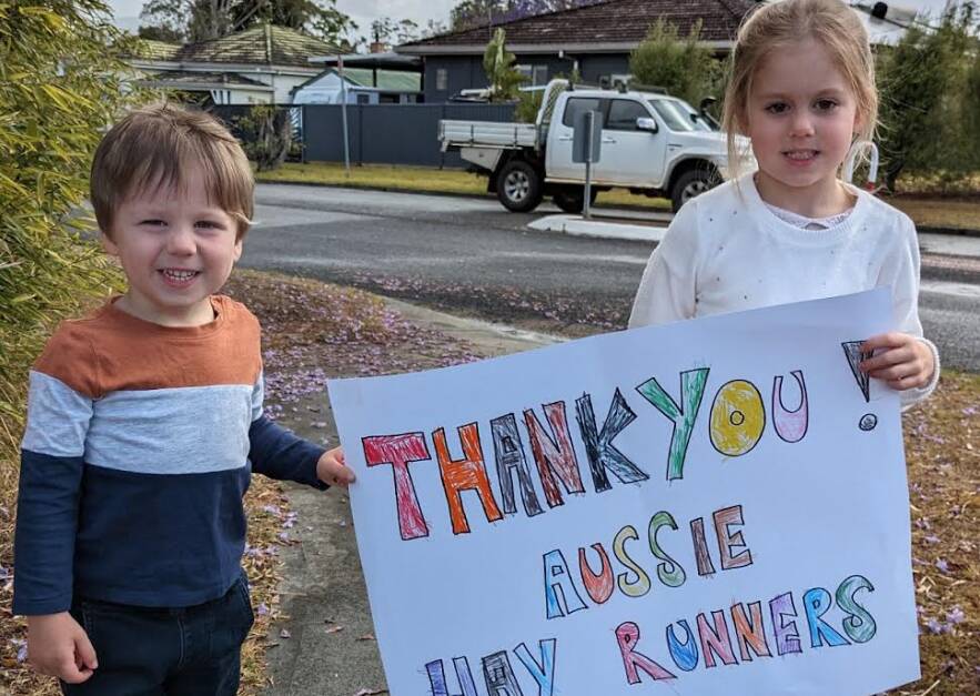 Archer and Amelia say thanks to the Aussie Hay Runners delivering hay to Wauchope. Picture supplied by Julius Huszarek