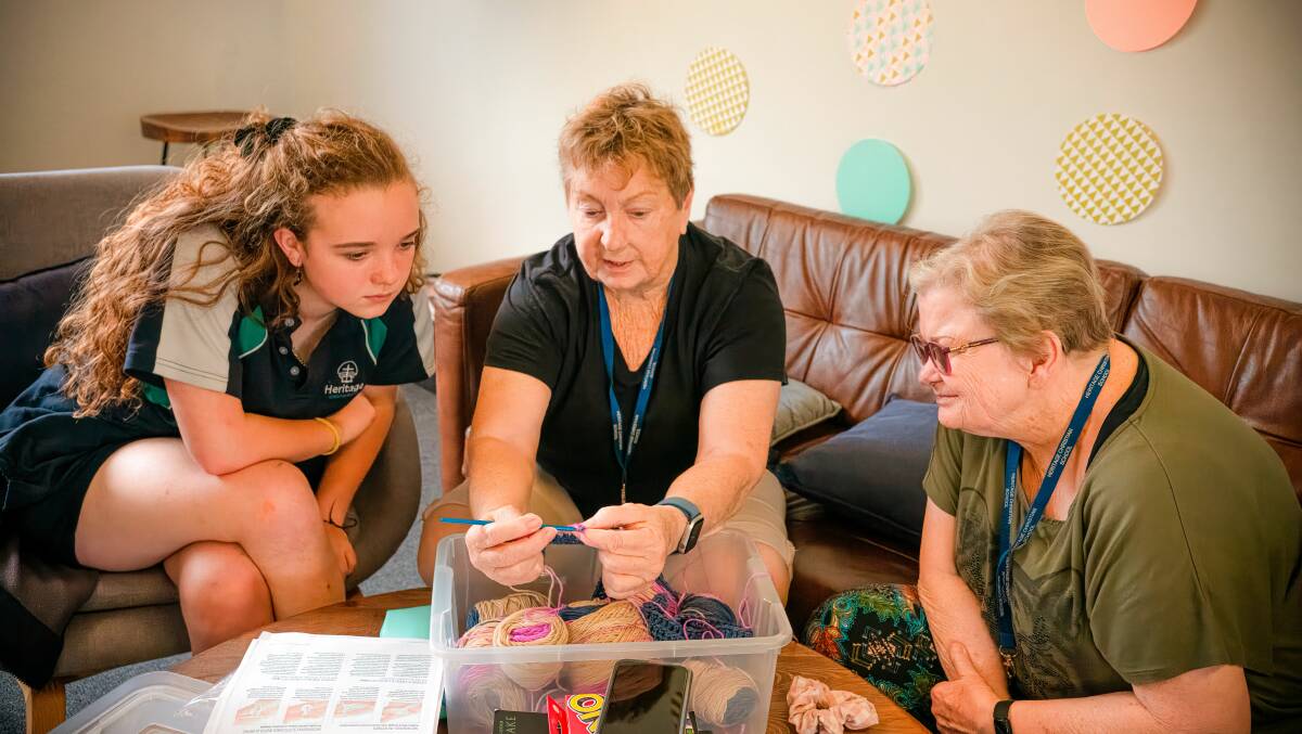 A student from Heritage Christian School watches as two aged care residents from RSL LifeCare Le Hamel Village demonstrate crocheting. Picture supplied