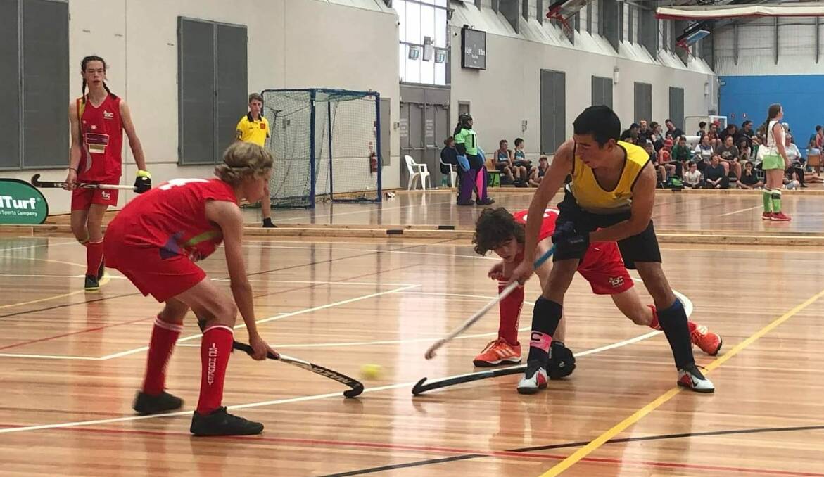 Tobias Toohey (right) battles for possession for Port Macquarie. Picture supplied by Port Macquarie-Hastings Hockey Association