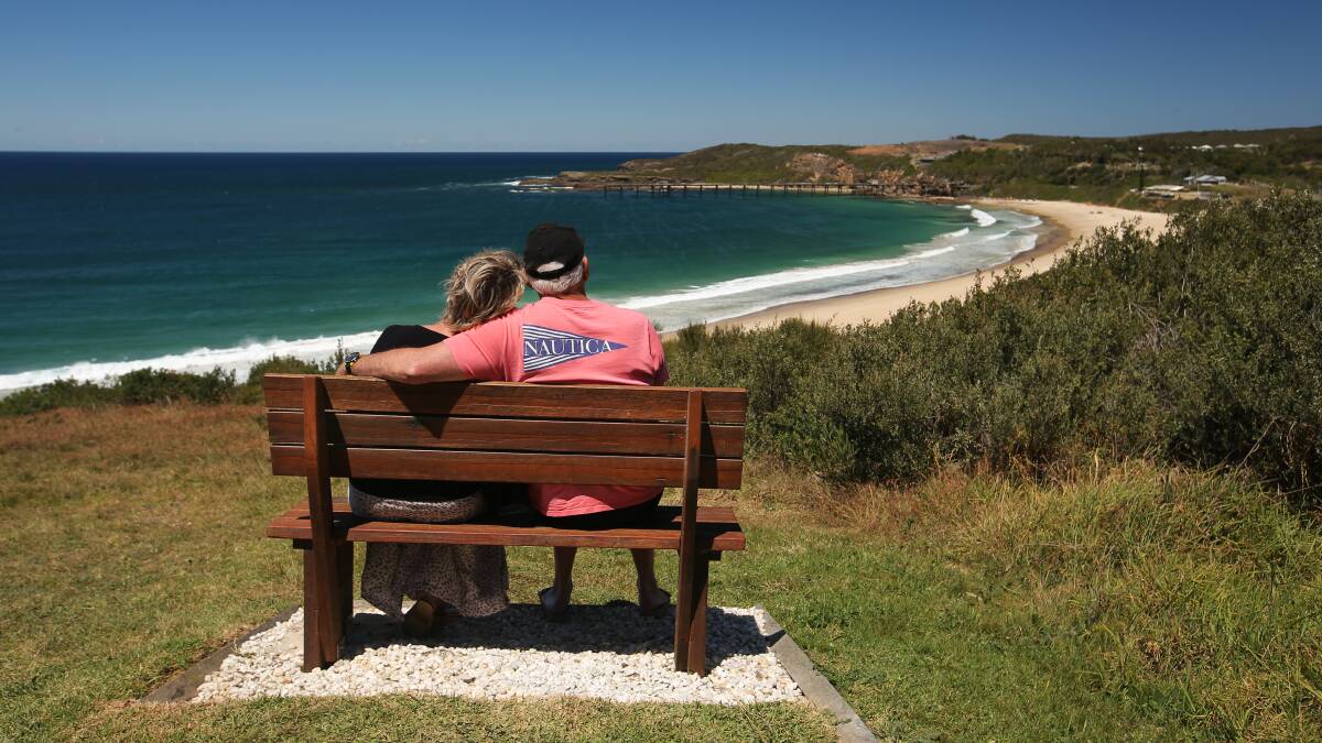 Glen and Cheryl Roberts sit on Jack's memorial chair overlooking Catherine Hill Bay. Picture by Simone De Peak 